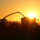 Machines agricoles travaillant au coucher du soleil pendant un épisode de forte chaleur en Nouvelle-Aquitaine, illustrant la prévention des risques pour les salariés.