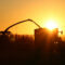 Machines agricoles travaillant au coucher du soleil pendant un épisode de forte chaleur en Nouvelle-Aquitaine, illustrant la prévention des risques pour les salariés.